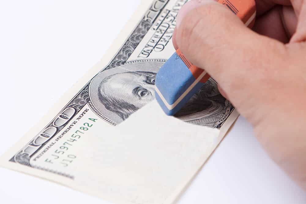 erasing 100 dollar bill with a blue eraser